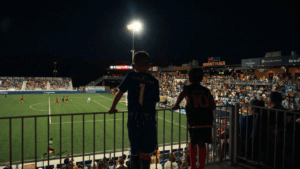 A crowd milling about outside a stadium.